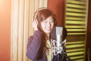 Asian singer producing song in recording studio